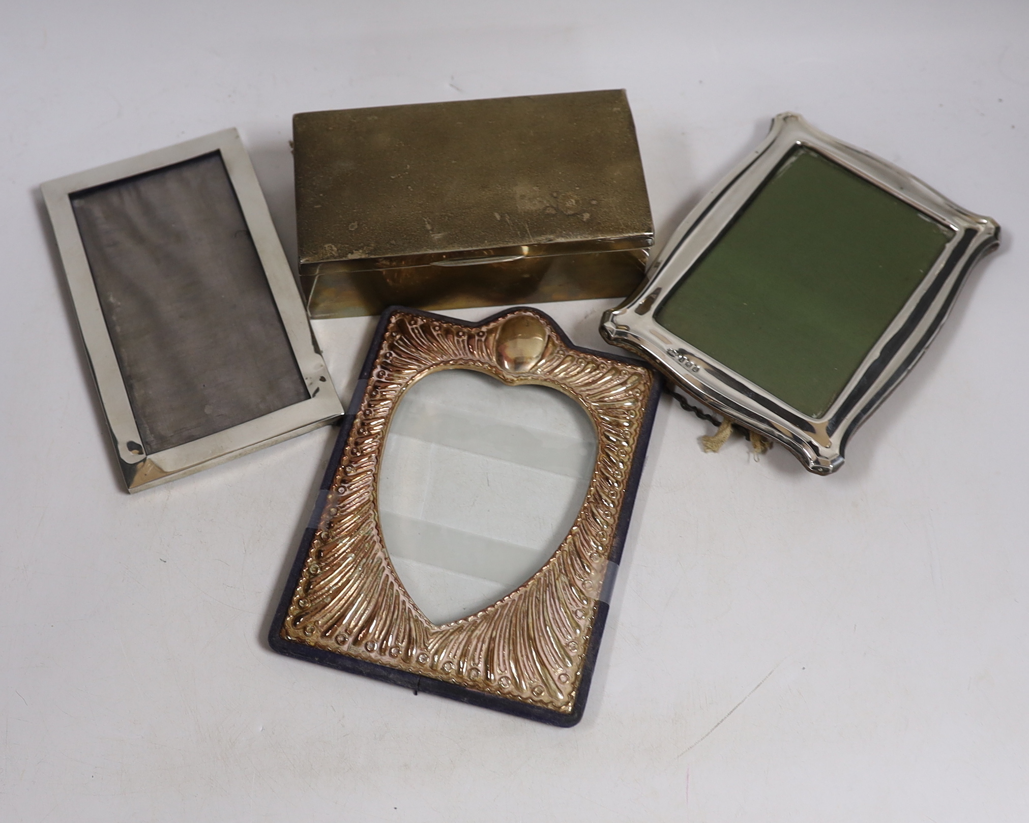 Two early to mid 20th century silver mounted photograph frames, largest 18cm, together with a George V silver mounted cigarette box.